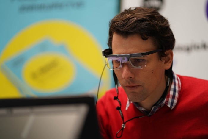 Muž používá sledování pohledu s brýlemi před počítačem