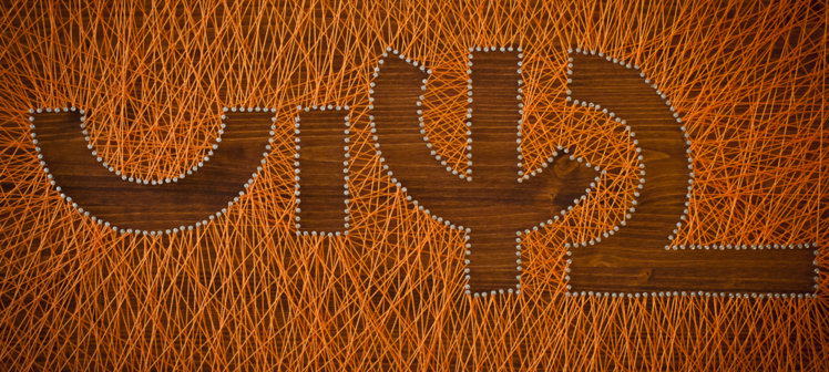 Dřevěný panel s abstraktním designem z nití a hřebíků