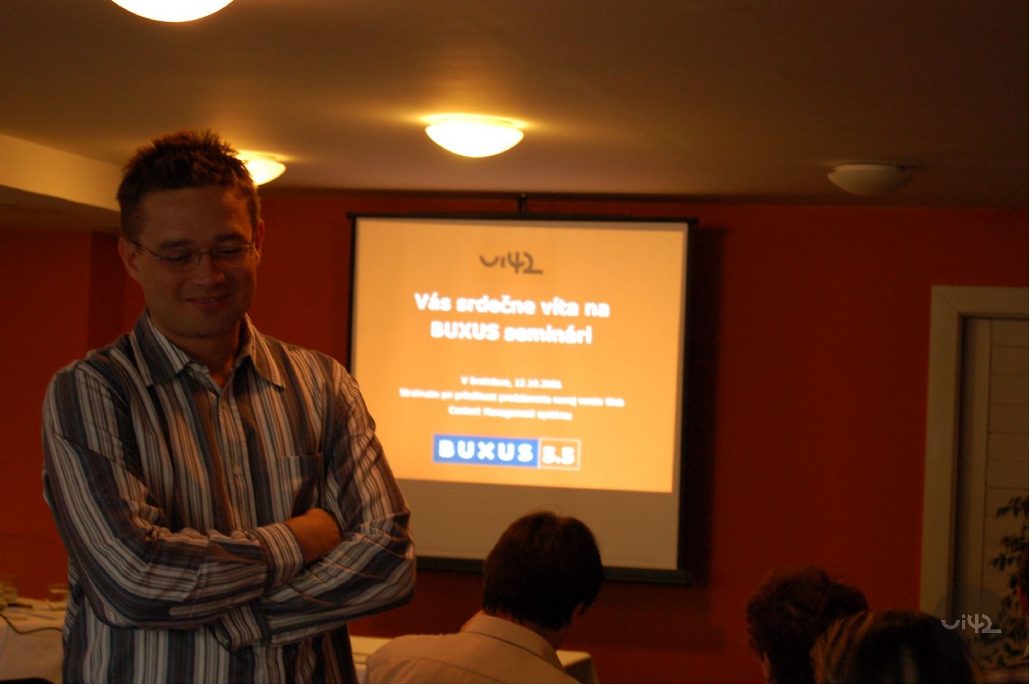 Muž na semináři před promítacím plátnem s nápisem BUXUS seminář.