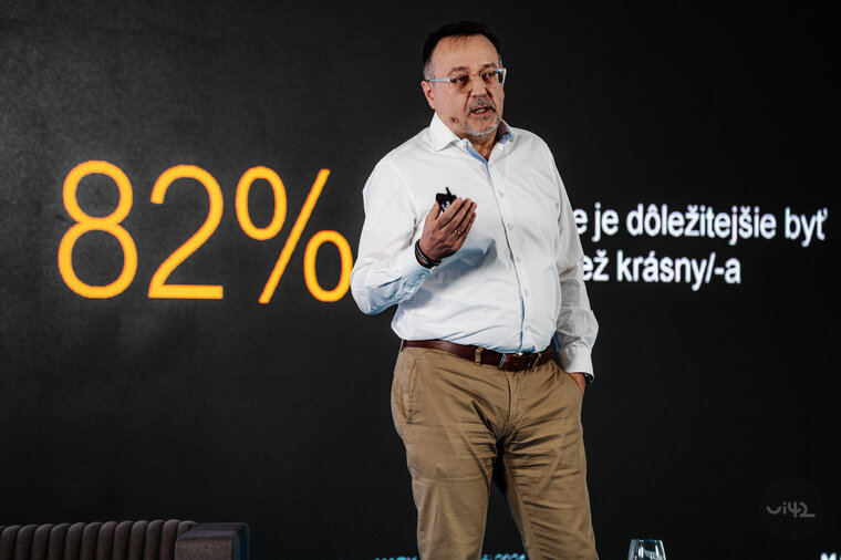 Přednášející na konferenci s textem na pozadí 82% a výrok o důležitosti být autentický