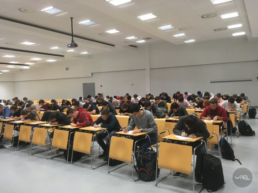 Študenti píšu skúšku v prednáškovej sále