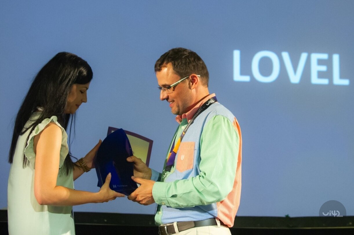 Dva lidé si vyměňují trofej na události MastersGate 2019.