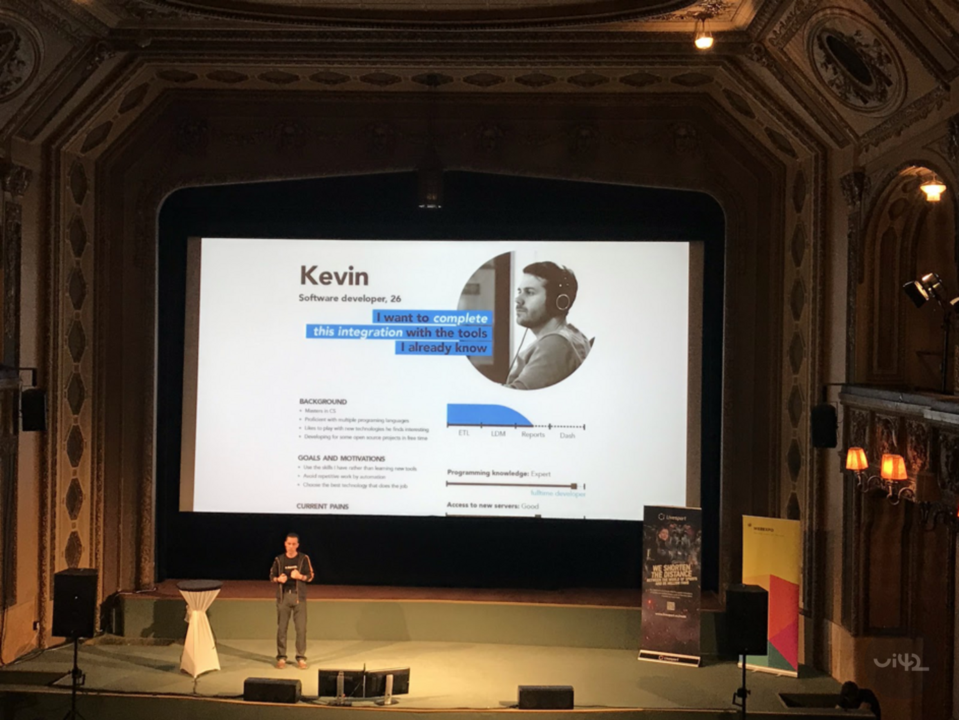 Prezentace na WebExpo 2019 s řečníkem na pódiu a velkou obrazovkou zobrazující profil softwarového vývojáře jménem Kevin.