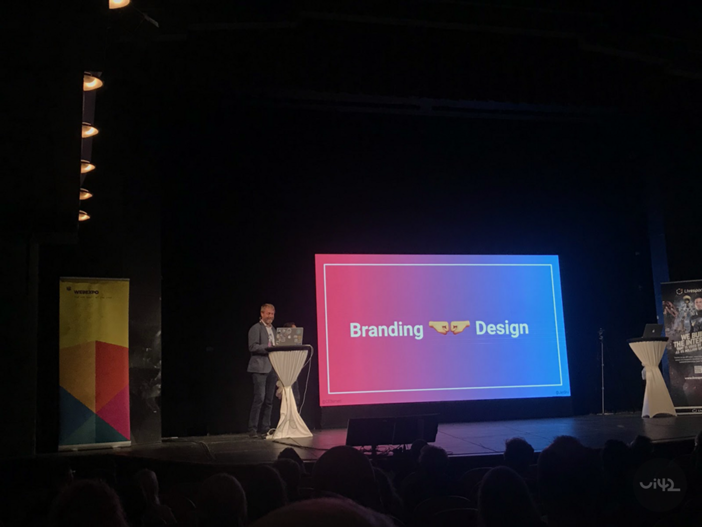 Prezentace na WebExpo 2019 o brandingu a designu s řečníkem na pódiu před obrazovkou s textem 'Branding Design'.