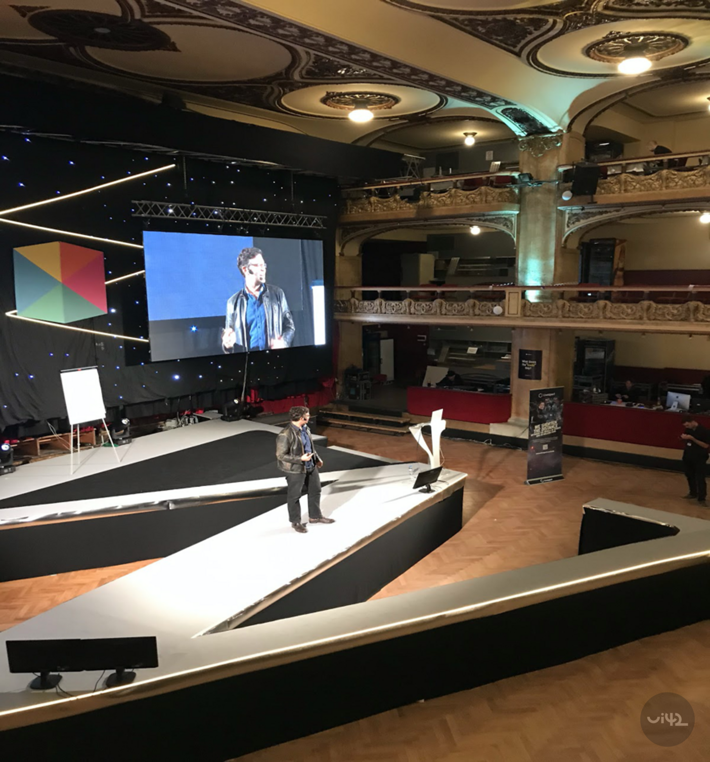 Prezentace na konferenci WebExpo 2019 v historické budově s pódiem a velkou obrazovkou.