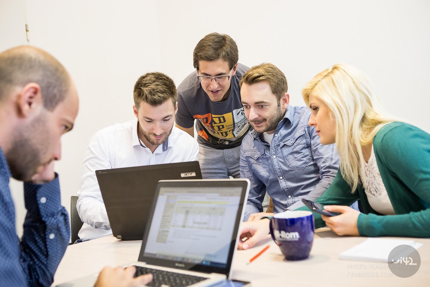 Skupina lidí u stolu během UX testování na počítačích