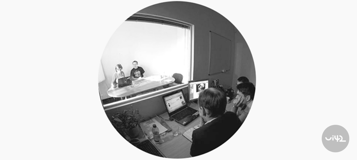 Lidé sledující UX testování přes sklo v kanceláři