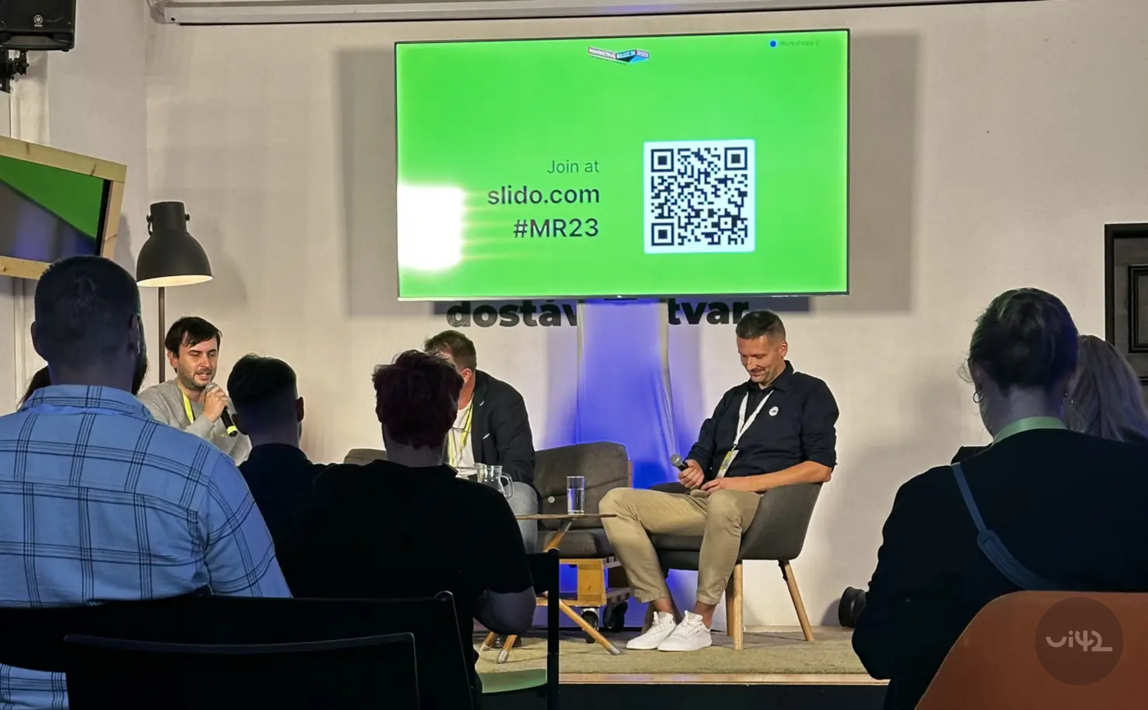 Diskuse na akci Marketing Rulezz s řečníky před publikem a obrazovkou s QR kódem a textem 'Join at slido.com #MR23'.